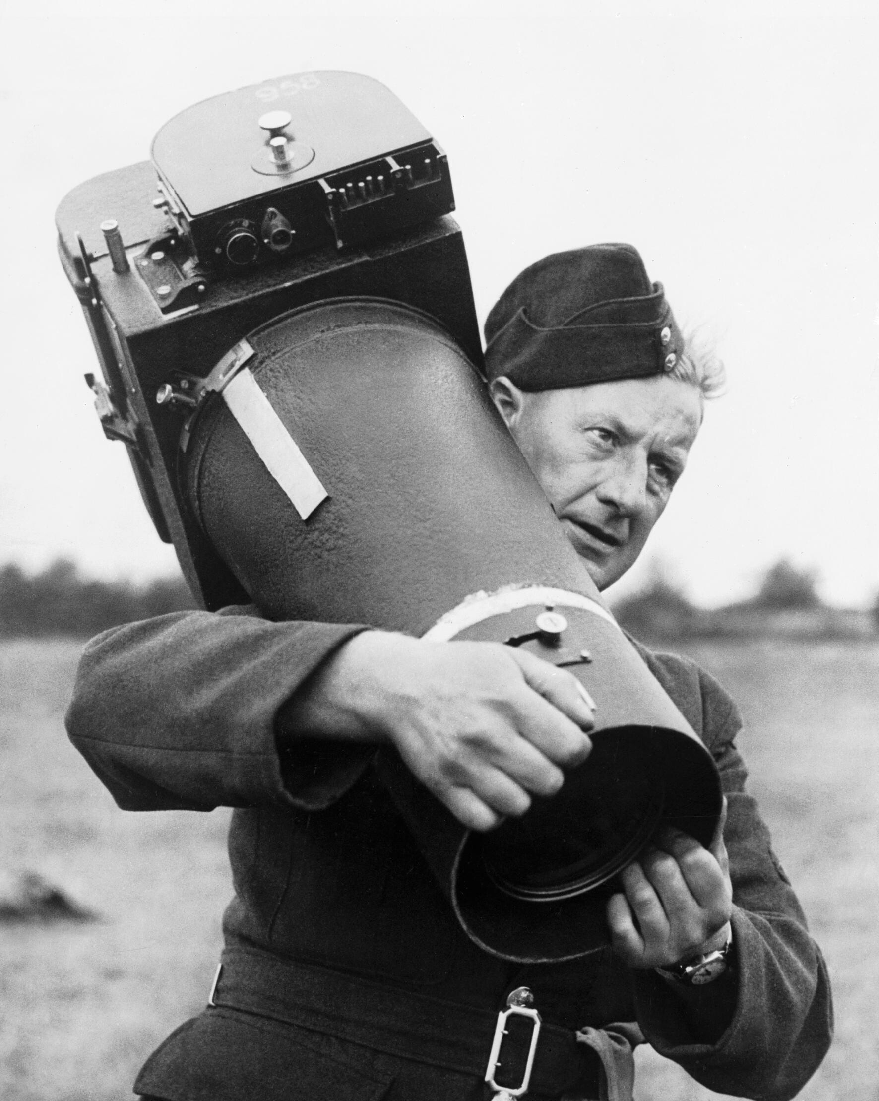 Groundcrew carrying an F.8 Mk II aerial reconnaissance camera at RAF Benson, August 1943